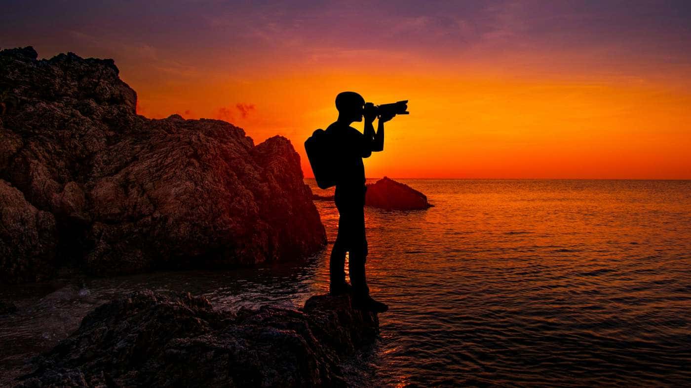 Photographer Capturing Ocean Sunset — desktop wallpaper preview